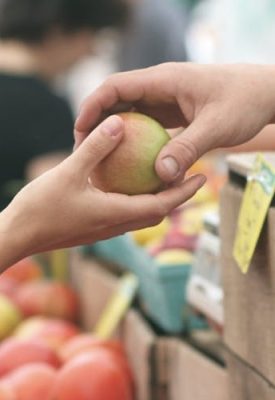 someone buying and apple in a market