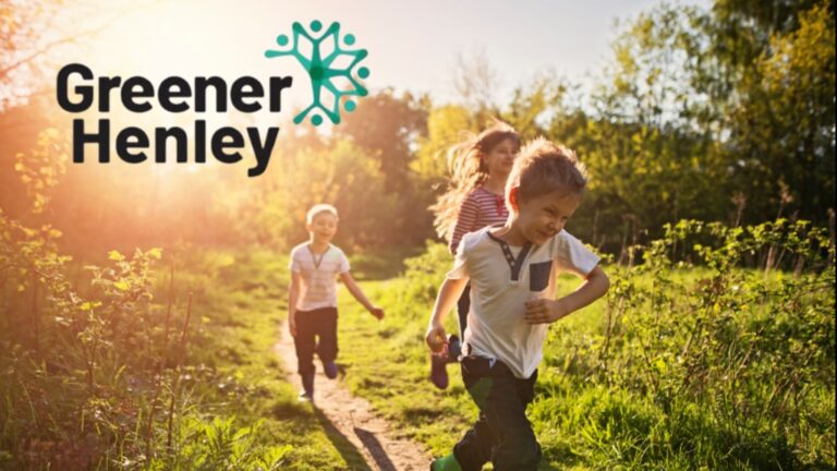 Happy children running down a green path with the sun low in the sky