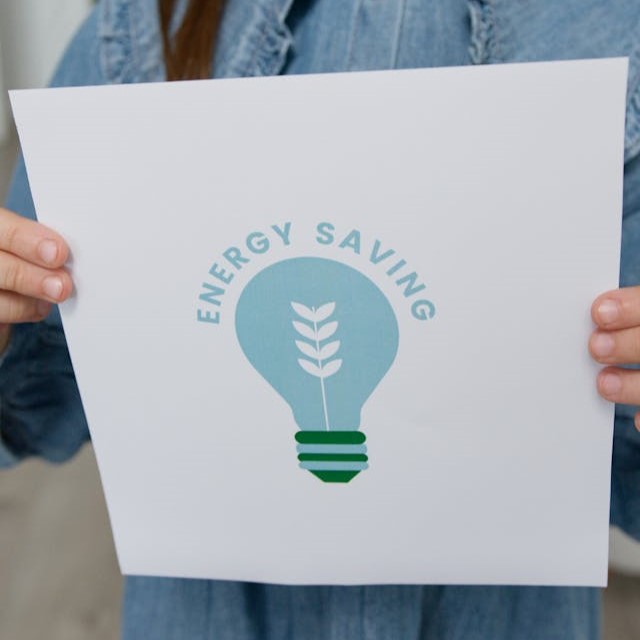 a child holds up a sign saying 'energy saving'
